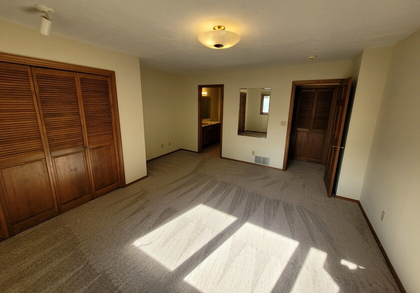 Large master bedroom. Closet on left, bathroom center, door to hallway on right. - 1711 W Koch St