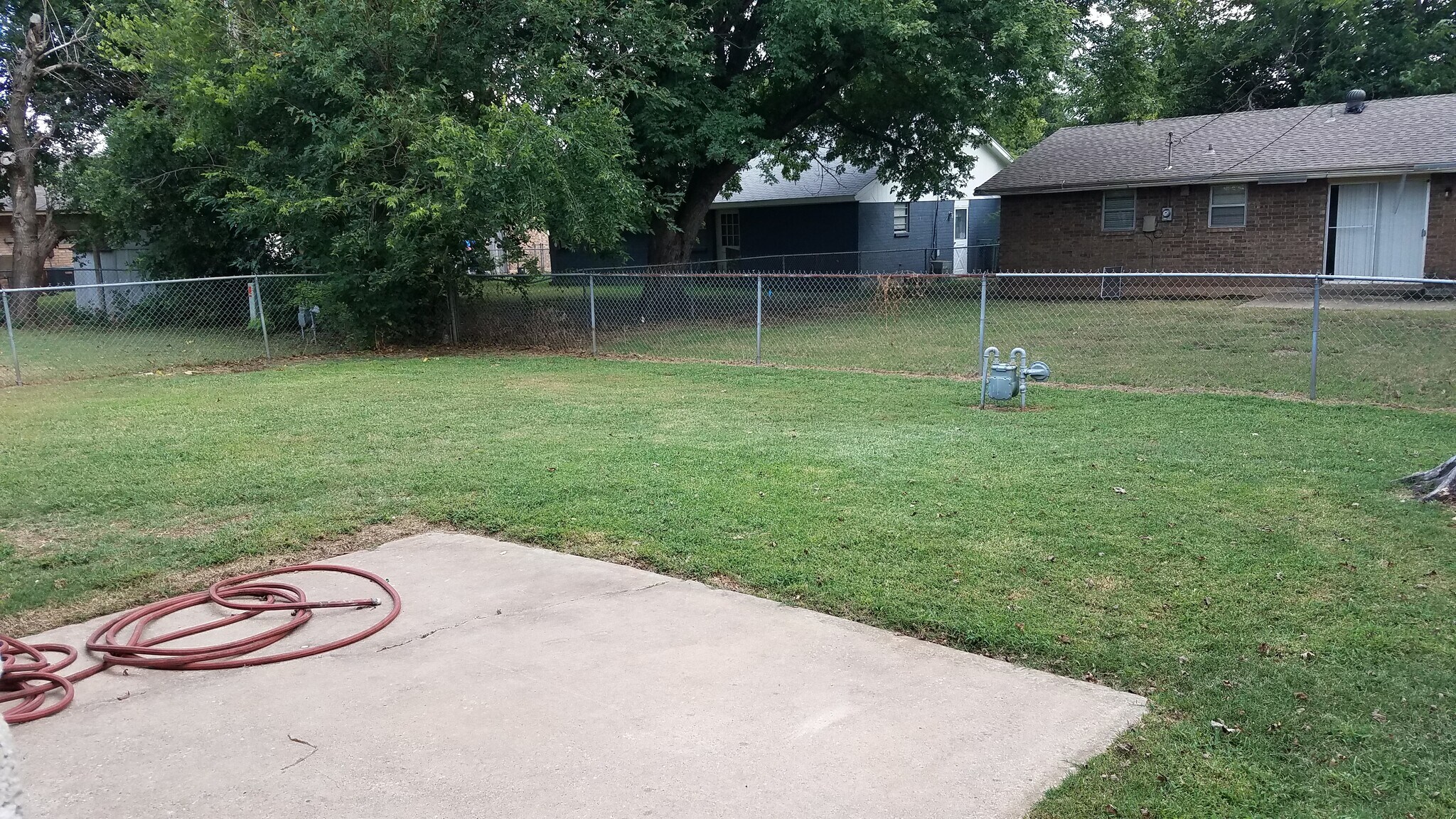 Backyard has a small patio area and is flat for easy mowing - 406 Gayclifee Terrace