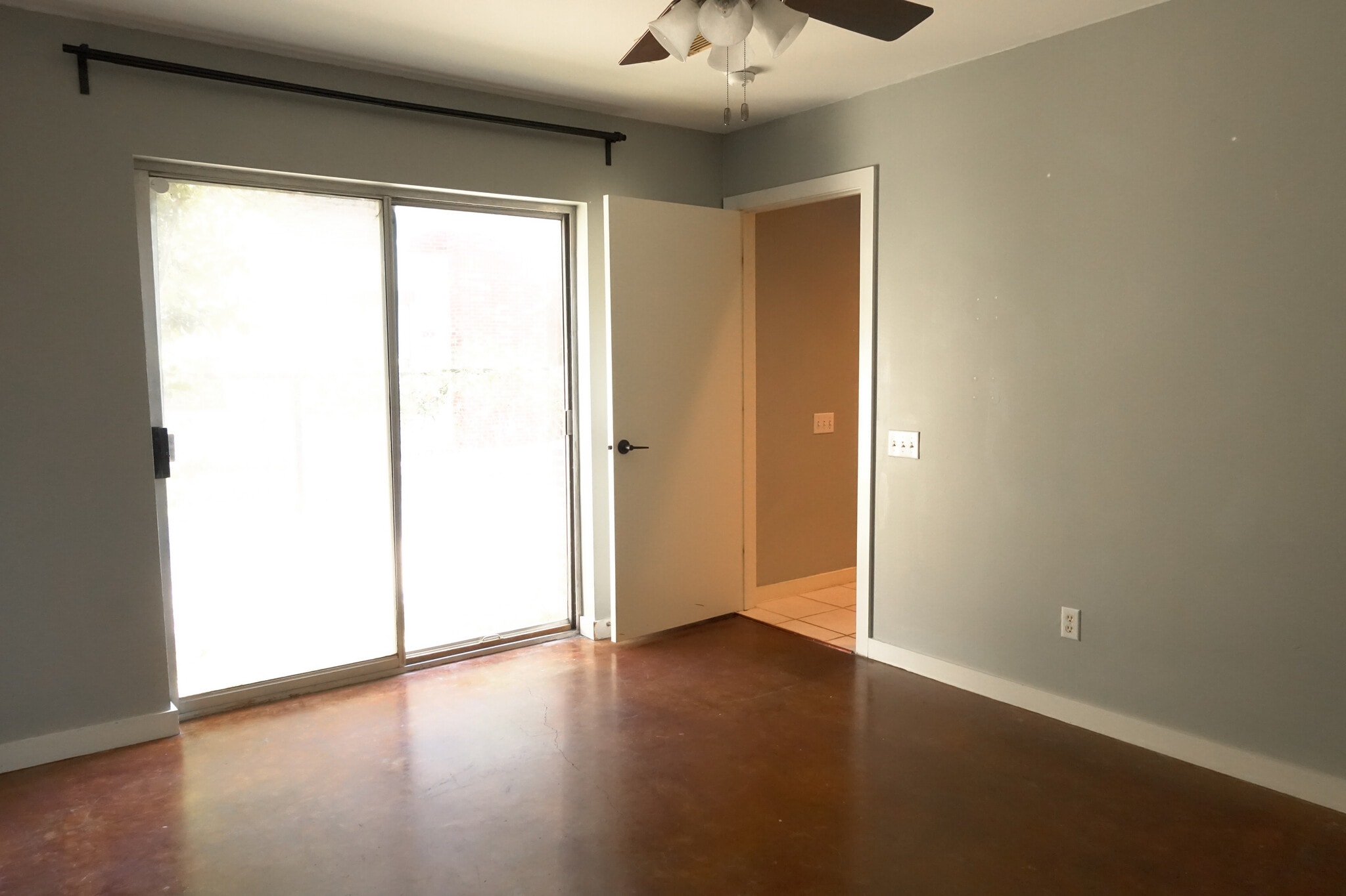 First floor bedroom with sliding door leading to front yard. Stained concrete floors - 918 Ruthven St