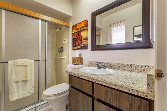 Master bathroom with granite counters and large shower with a small bench. - 10113 W Pebble Beach Dr