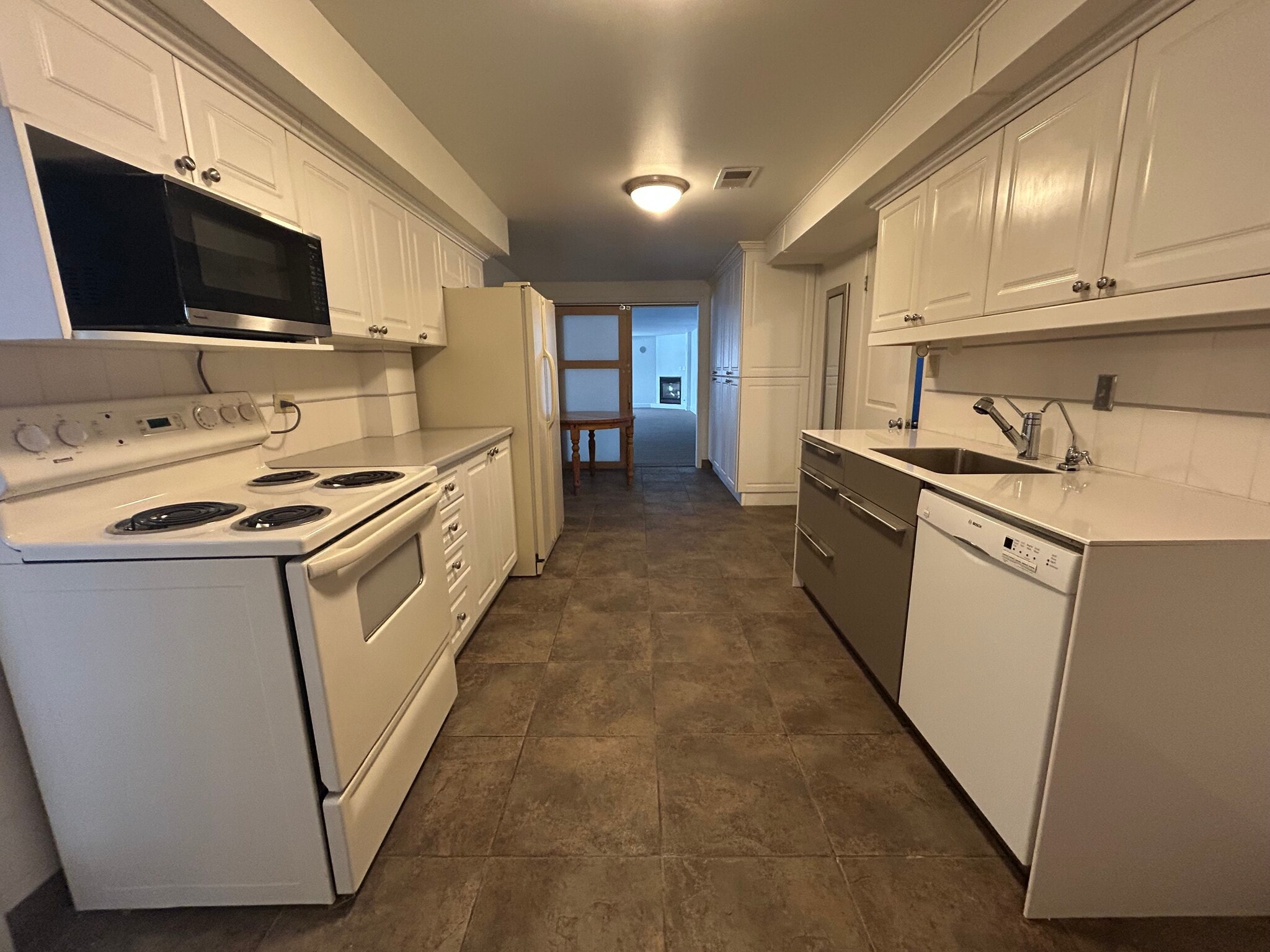 Kitchen with view to living area. Bedroom is to left of stove. - 6555 W 10th Pl