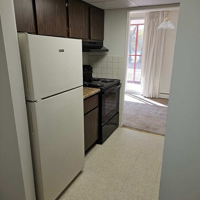 Step into a bright and cozy kitchen that opens into a sunlit living space. - Lake Club Apartments