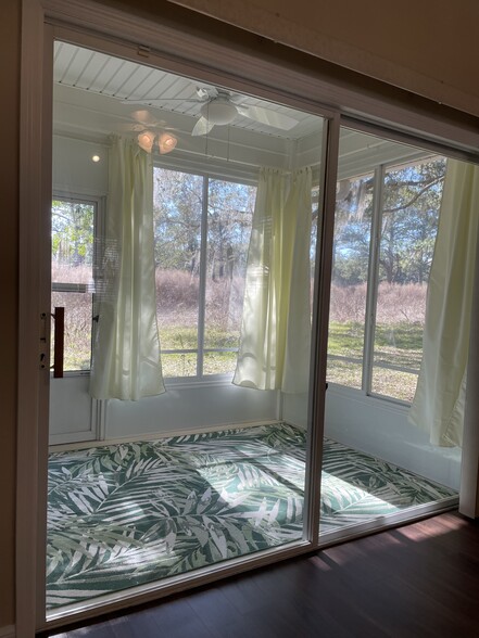 Enclosed back porch lets in wonderful sunlight into living room. - 13200 W Newberry Rd