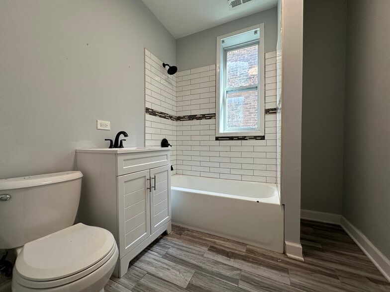 Fully renovated bathroom with subway tile tub surround and new vanity and toilet - 5653 S May St