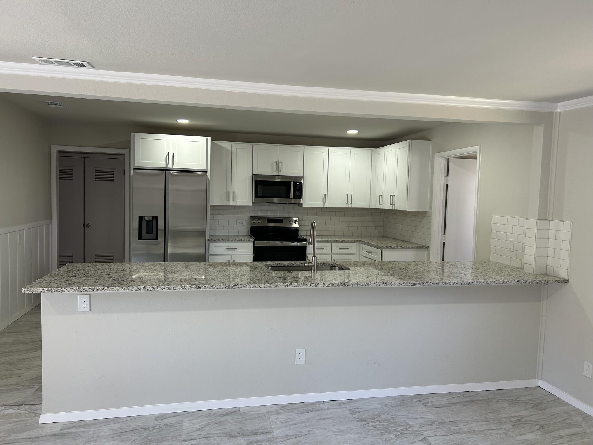 View from Dining Room into Kitchen with Hallway on left and Laundry on right - 3404 Martin Lydon Ave