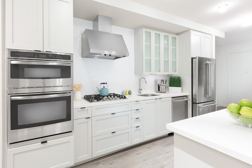 Kitchen with white cabinetry, quartz stone countertops, ceramic tile backsplash and stainless steel appliances - Avalon Dogpatch