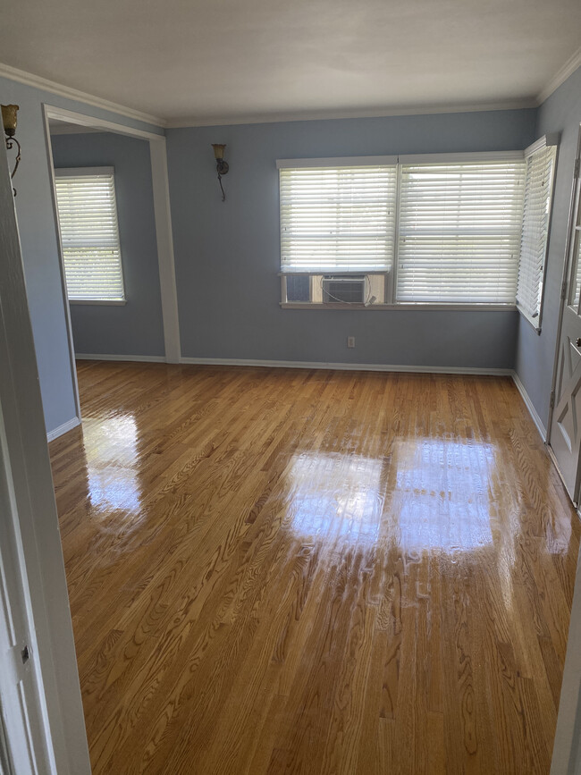 Living room has natural hardwood floors and is open to the dining area. - 1857 Pandora Ave