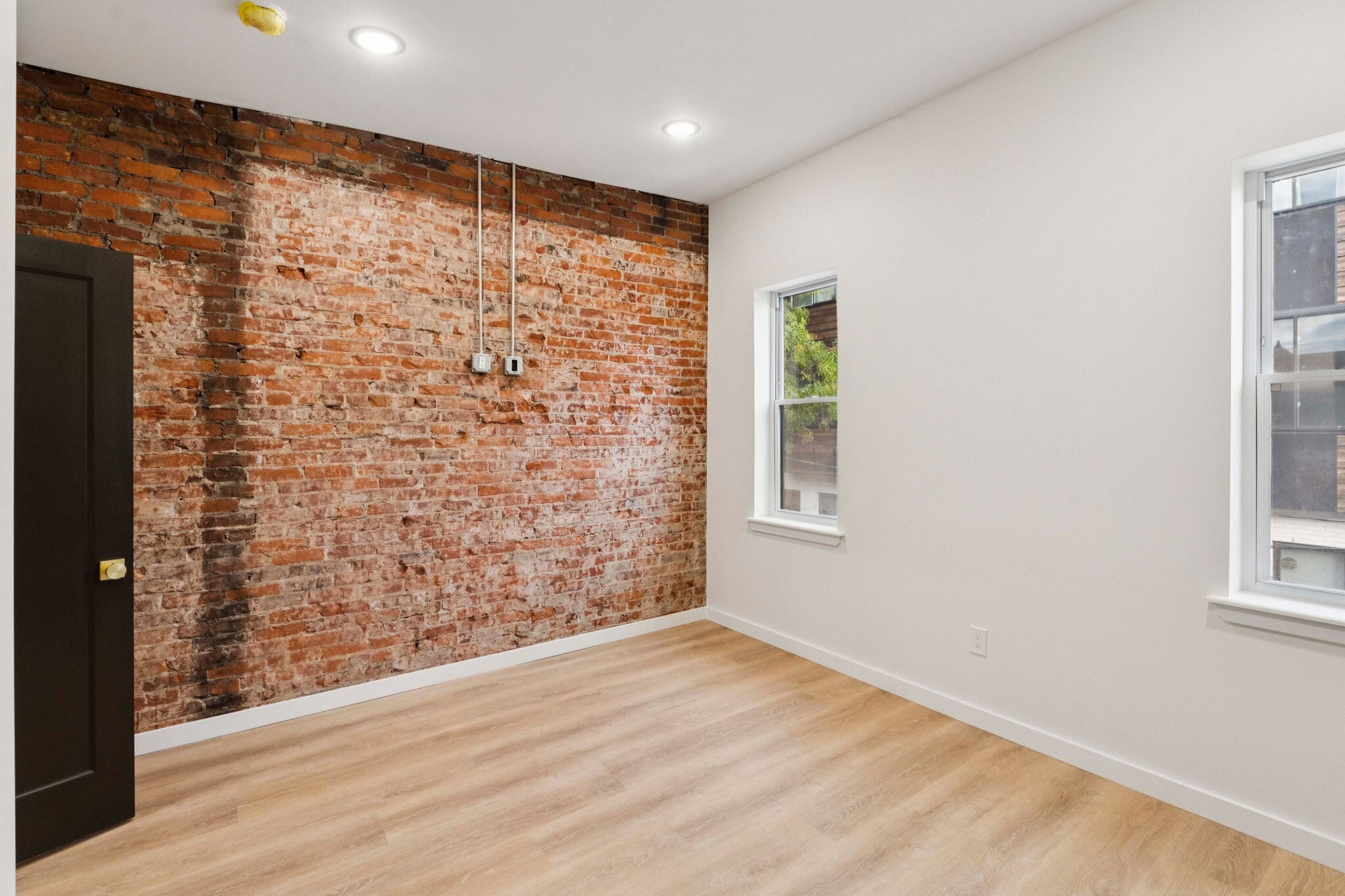 Primary bedroom with exposed brick and bedside lighting - 1544 S Bambrey St