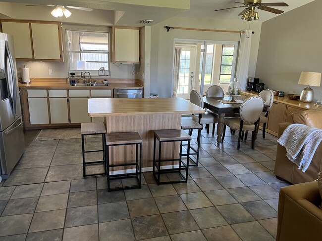 Seating for eight in the kitchen dining area. Four seats at the bar and four at the table. - 247 SE Santa Barbara Pl