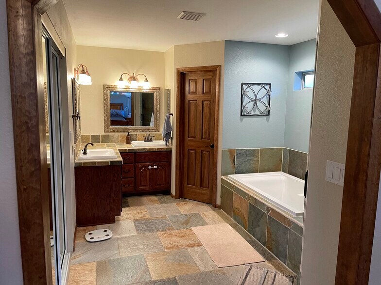 Primary Bathroom, slate tile, walk-in closet, dual sinks and large soaking tub - 3476 S Debbie St