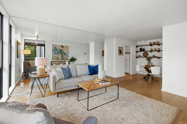 Full floor to ceiling mirror wall floods the living space with light. Your plants will love it! - 730 Bellevue Ave E