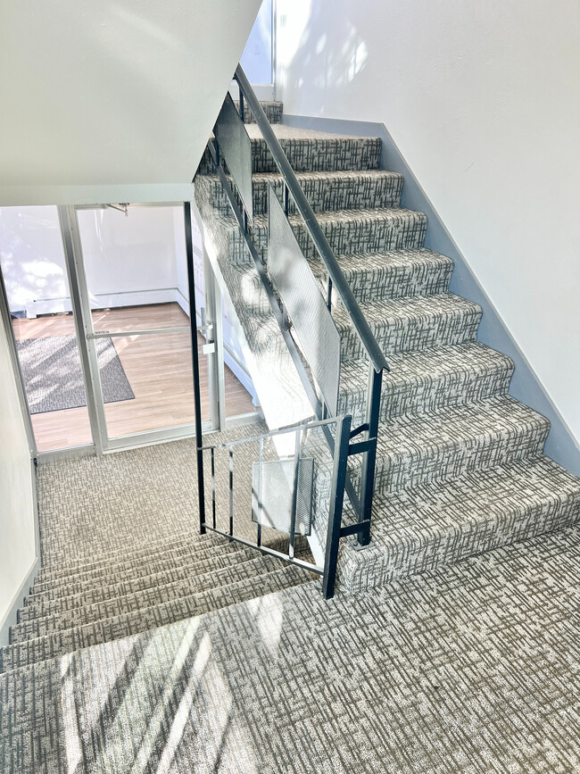 Experience modern elegance with this stylishly designed staircase, perfect for any contemporary home. - Rhapsody Apartments