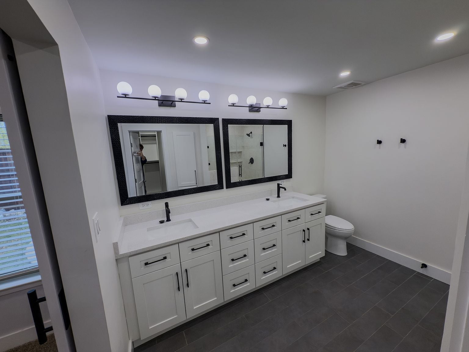 Main bathroom with double vanity, dual framed mirrors, and modern black fixtures - 2006 Candle Ct