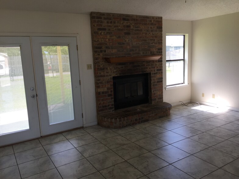 Living room (prior to repaint). French doors (with internal window blinds) opens to covered back patio. - 613 Van Zandt St