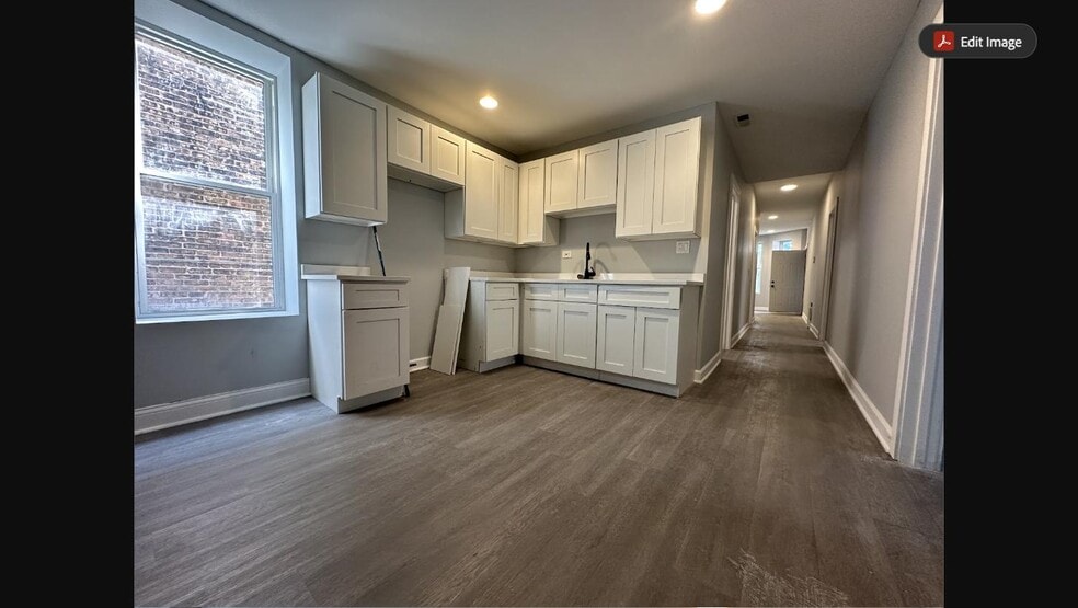 Newly renovated kitchen with white shaker cabinets opening to a long hallway - 5653 S May St