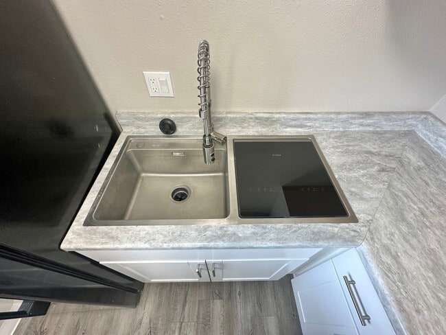 Experience the elegance of a contemporary kitchen with premium finishes. - Allison West Apartments
