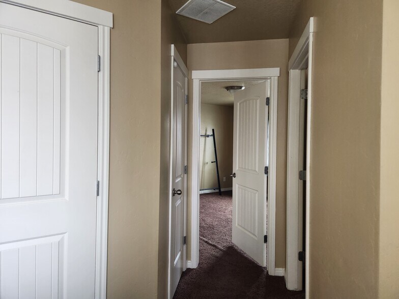 Top of stairs, right hand side. Left to right: water heater furnace area, closet, master bed, bedroom - 1584 N 565 W