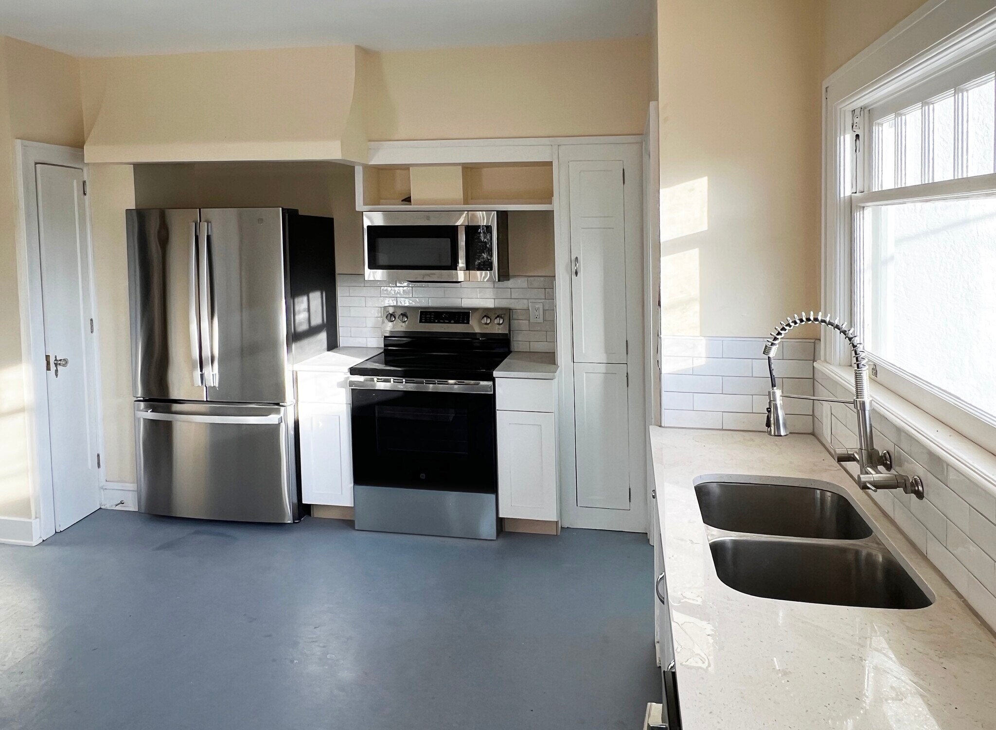 Remodeled kitchen thoughtfully combines new appliances and quartz countertops with vintage cupboards - 3448 SW Canby St