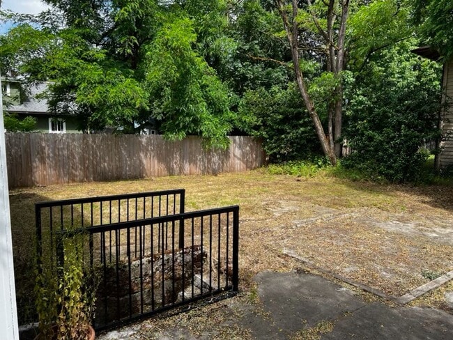 Building Photo - This 3-bedroom 1-bathroom house has a large front yard and a mostly fenced backyard.