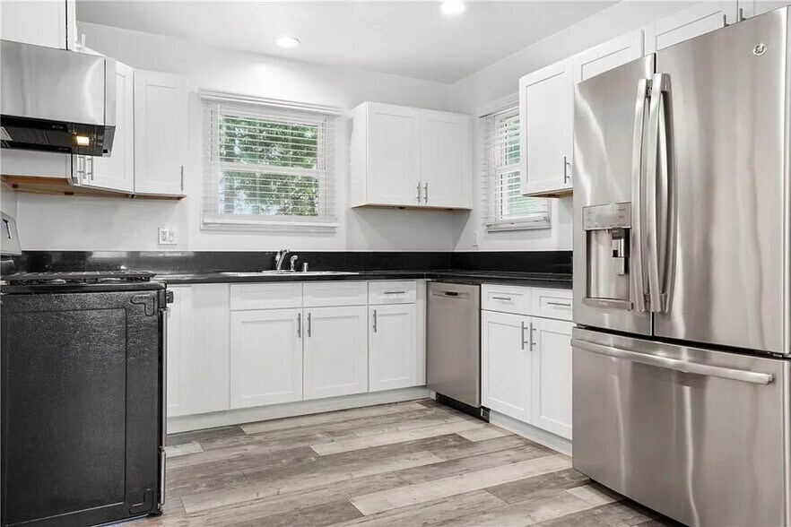 Updated kitchen with white shaker cabinetry, stainless appliances, stone counters and more - 1500 Voorhees Ave