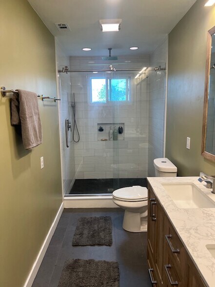 Walk-in shower, modern finishes, and window with backyard view. - 953 13th Ave S