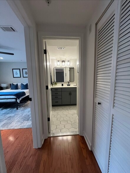 Hallway with geometric tile flooring leading to the primary suite. - 4079 S Four Mile Run Dr