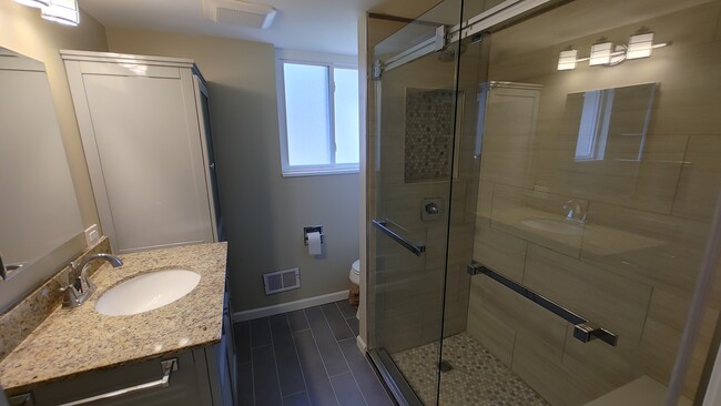 Bathroom 1 - renovated, glass sliding door shower with bench - 6934 Winding Way