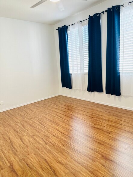 Bright upstairs bedroom with wood-look flooring. - 1177 W Laredo Ave