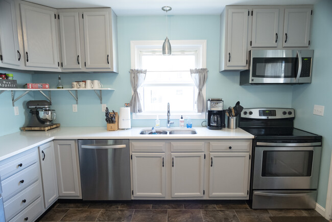 Light gray cabinets and stainless appliances in this charming kitchen - 8 Christine Rd