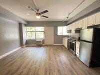 Hobron Apartments living area and kitchen area with appliances and cabinets - Hobron Apartments