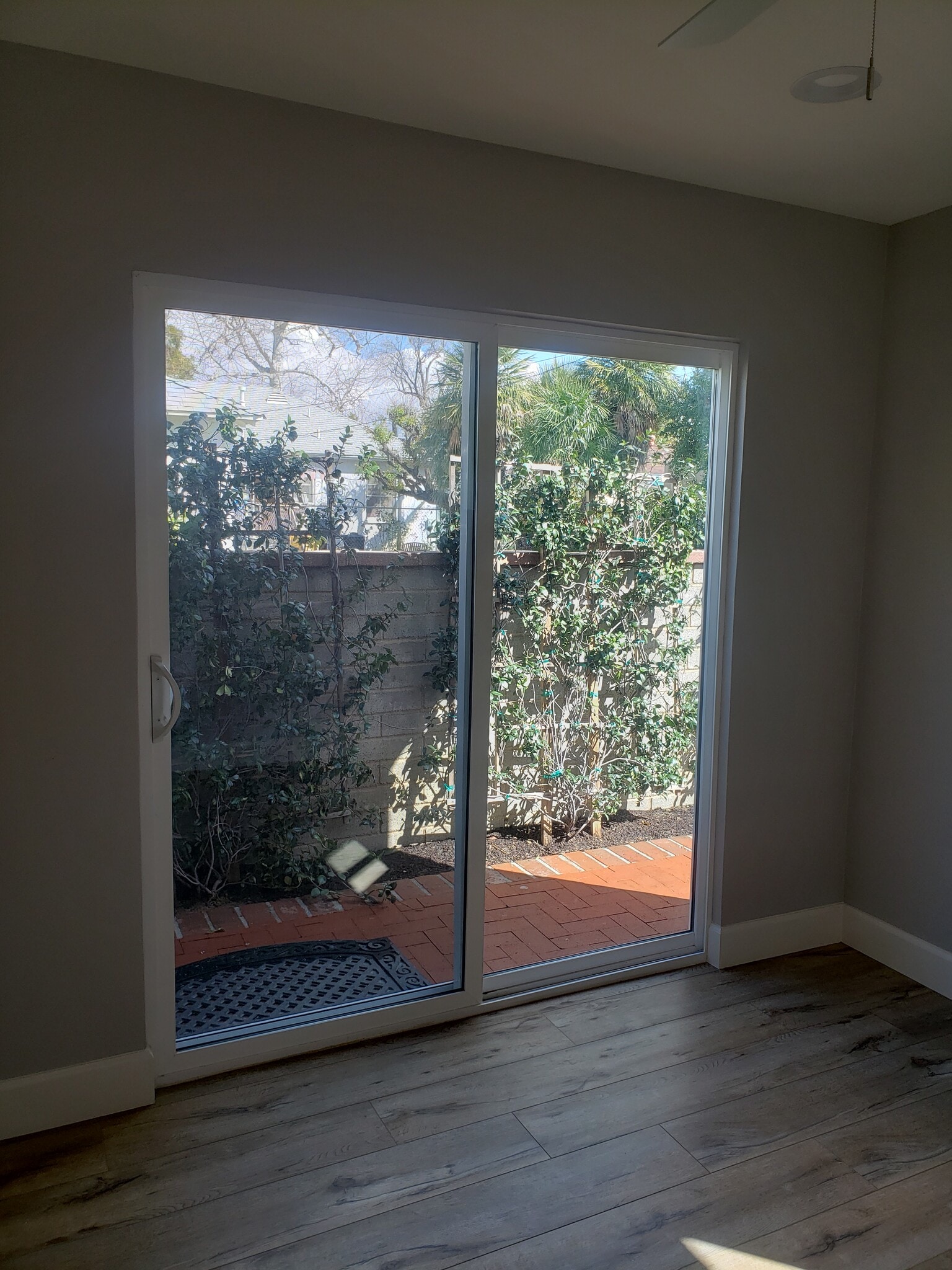 glass sliding door in the bedroom. Star Jasmines are now fully filled in. - 7650 Ostrom Ave