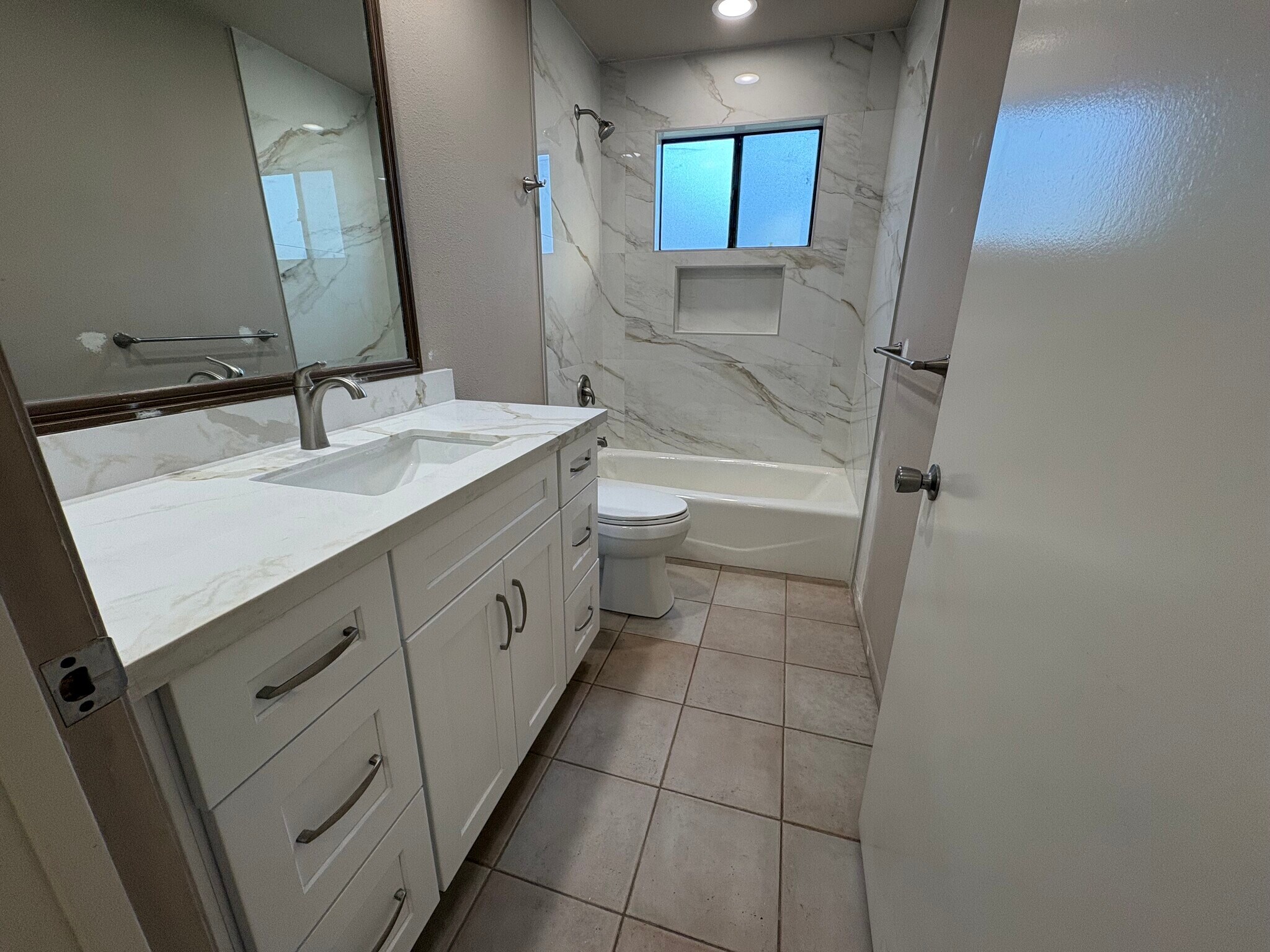 Hall bath has all NEW vanity, quartz countertop, added shower, tile and hardware. - 8566 Larkhall Cir