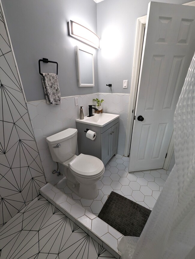The bathroom is completely updated with custom tile work a rain shower and modern fixtures. - 4107 Crane St