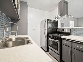 Blue tiled kitchen with stainless steel fridge, oven, and fixtures. - 10620 NoHo