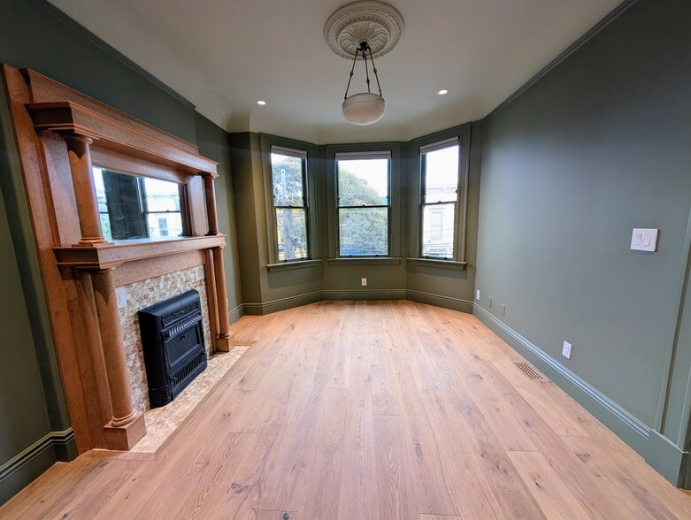 Formal parlor in the front of the residence. Bay window, original fireplace mantle and chandelier. - 328 Lexington St