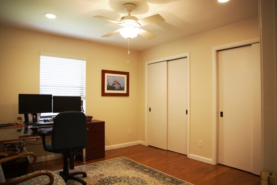 Bedroom 4 has wall of closets, laminate wood floors, and lighted ceiling fan. - 2662 NW 42nd St