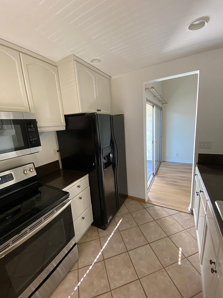 Tiled kitchen with generous cabinet and counter space - 8305 Summertime Ln
