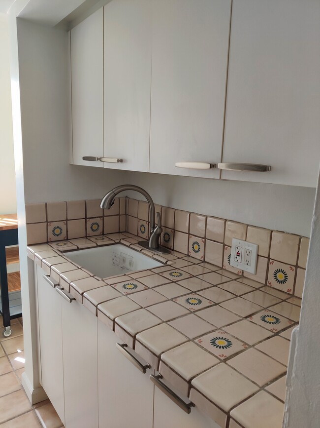 Kitchen with tile countertop with several cabinets - 117 Lighthouse Ct