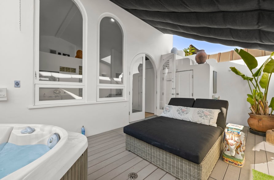 Primary suite balcony with comfortable outdoor seating and shaded lounging. - 120 Mast Mall