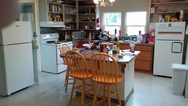 Kitchen & eating area - remodeled 4 years ago. Two newer full-sized refrigerators included. Three swivel bar stools included. Just to the left of the stove is the door to the laundry room. Behind is the eating area-all purpose room and the living room - 804 NW 29th St