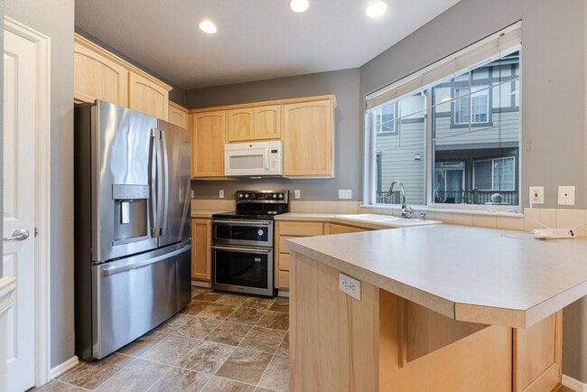 Building Photo - Lovely and bright townhouse with a hard wood flooring throughout, a 2 car garage, AC & more!