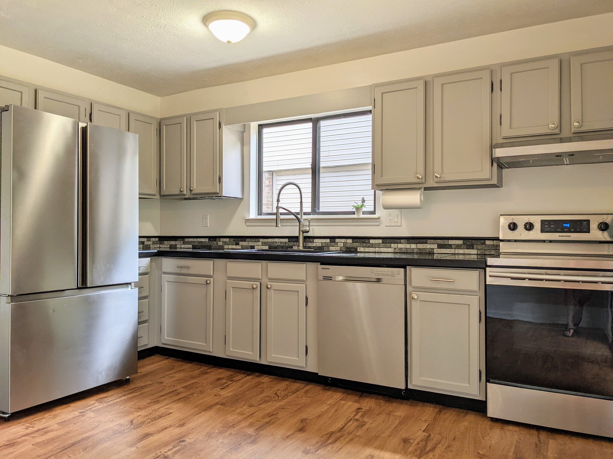 Kitchen with ample cabinet space, stainless steel refrigerator, dishwasher and electric range. - 1649 Summerhill Dr