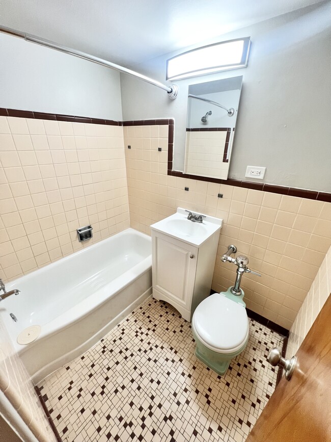 Step into this elegantly designed bathroom that combines vintage charm with modern elegance. - The Birney Apartments