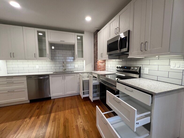 Showcasing the Trash/Recycling Drawer, Spice Drawer next to Oven, and Ample Storage Space - 3880 Walsh St
