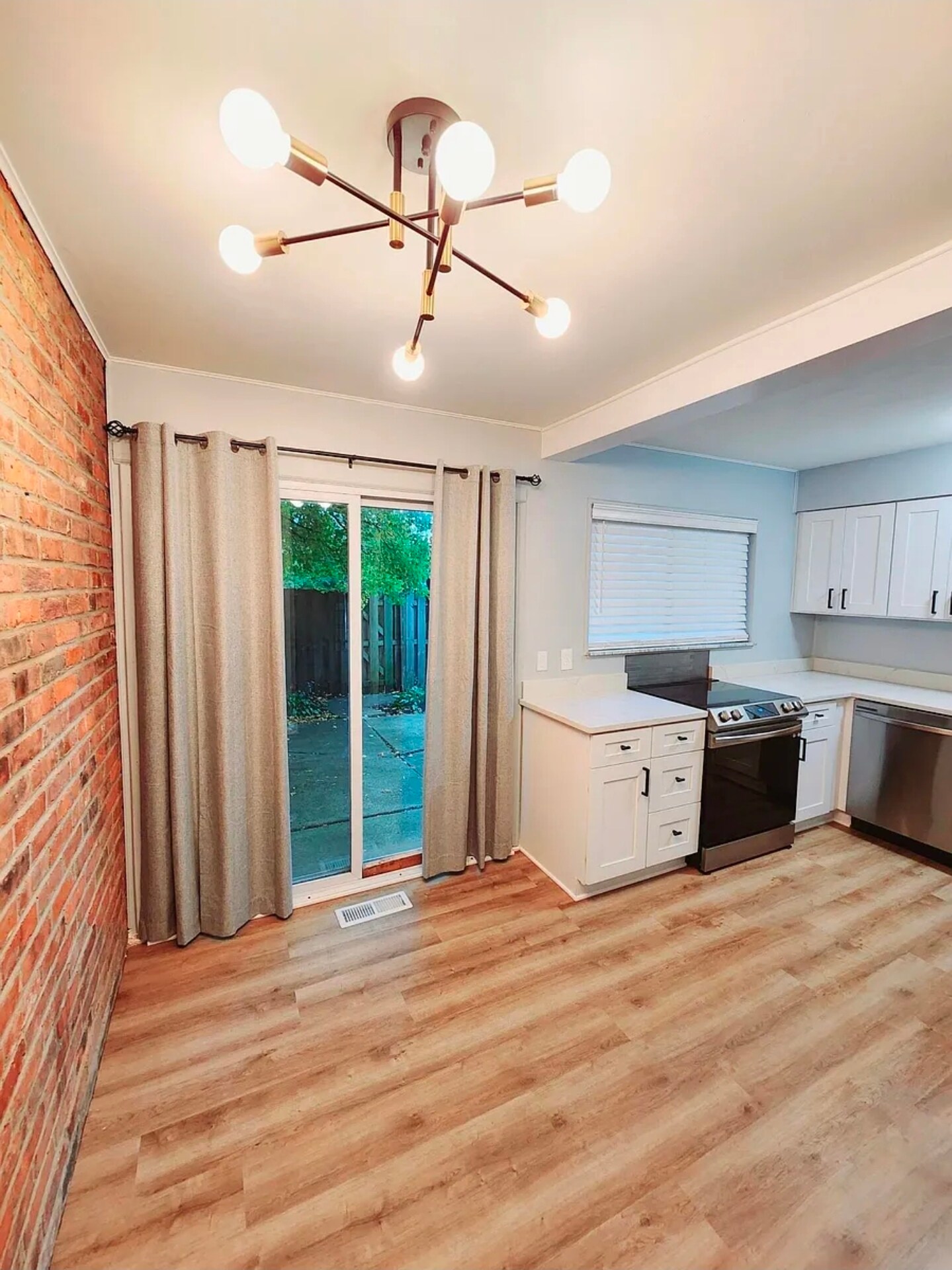 The open dining and kitchen area offers natural light, patio access, modern lighting, and durable pl - 21 Richmond Sq