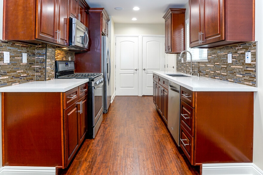 Quartz Countertop kitchen with glass bk splash and soft closing cabinets - 7522 Fountain Ave