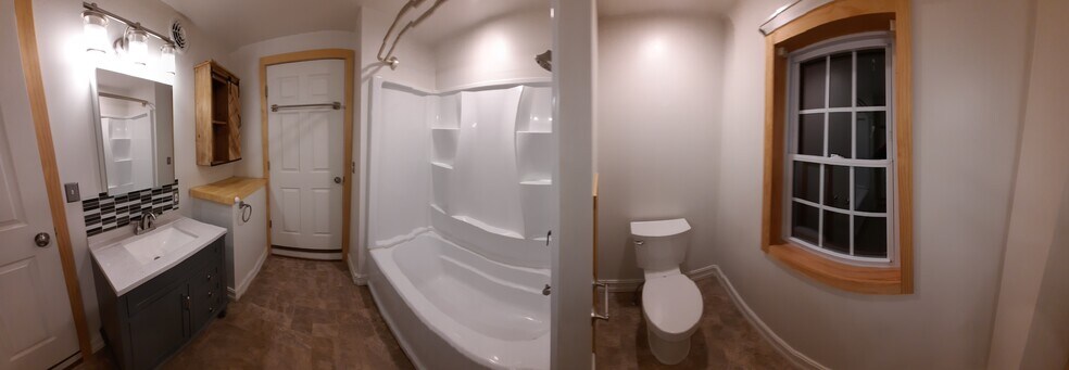 SURROUND TUB/HARD SURFACE VANITY/SS FAUCET/MATCHING THREE LIGHT OVER GLASS CABINET - 247 Main St