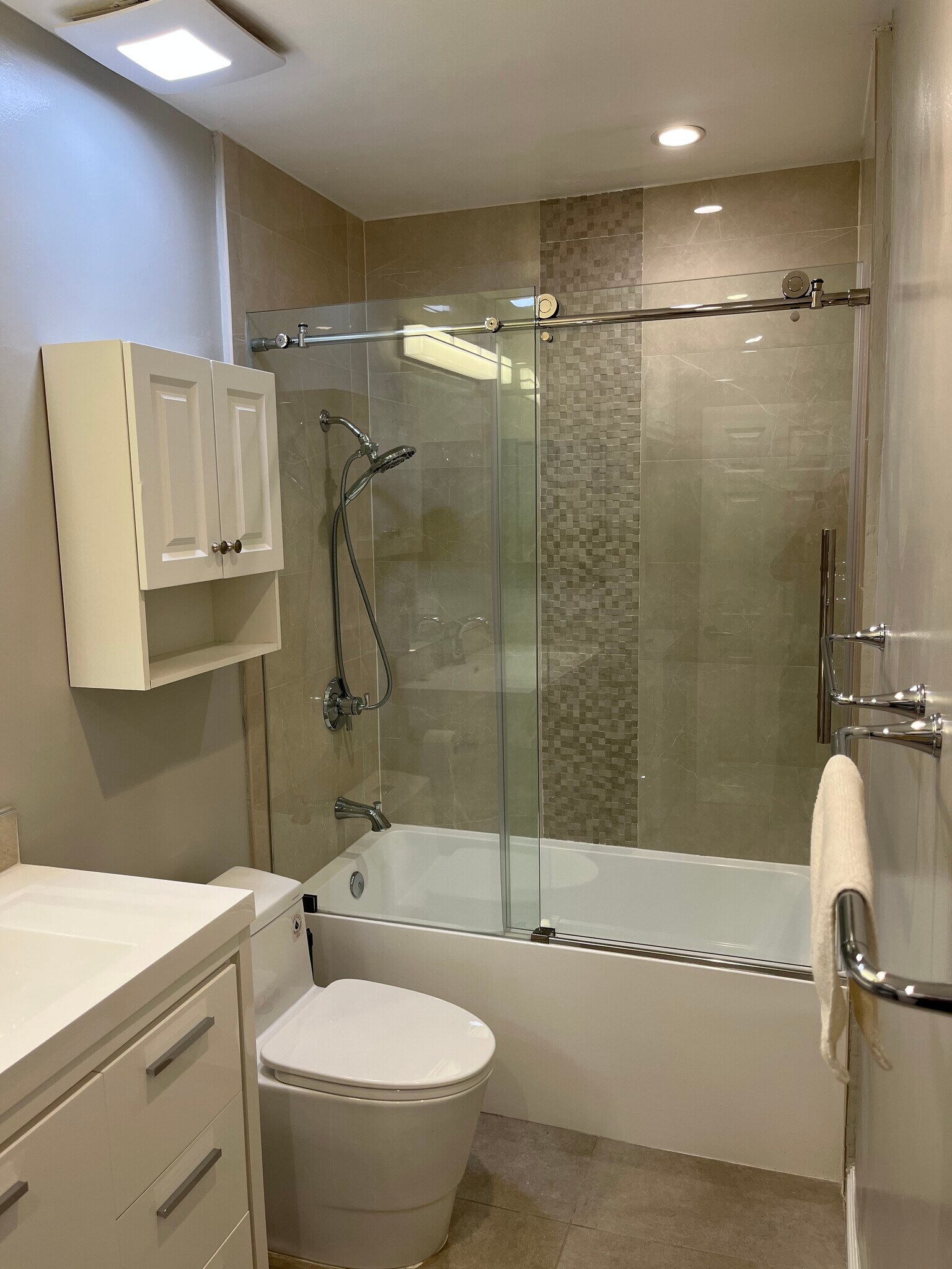 new shower with frameless door and over-toilet cabinet - 1828 Camden Ave