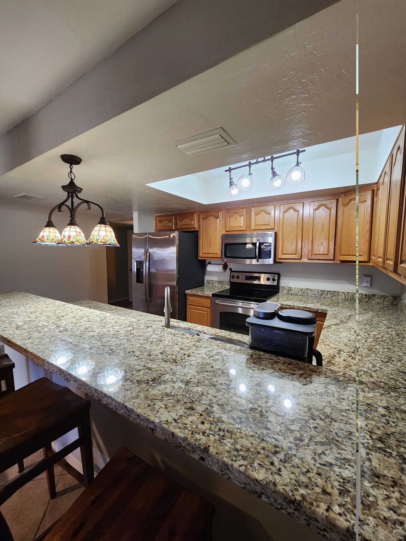Breakfast bar overlooks modern kitchen. - 5050 N 81st St