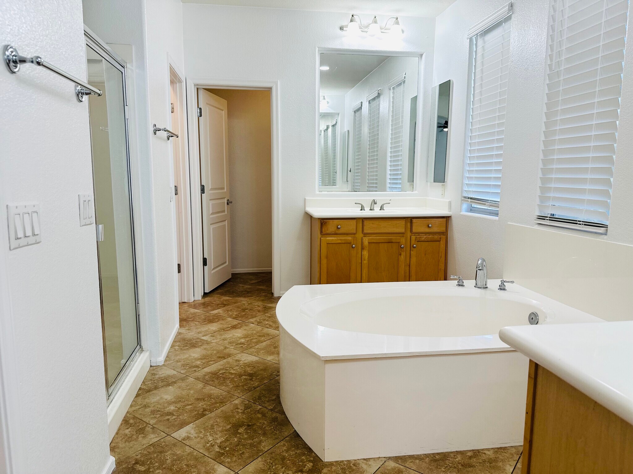 Primary bath with a soaking tub, separate shower, dual vanities, and two walk-in closets. - 1177 W Laredo Ave